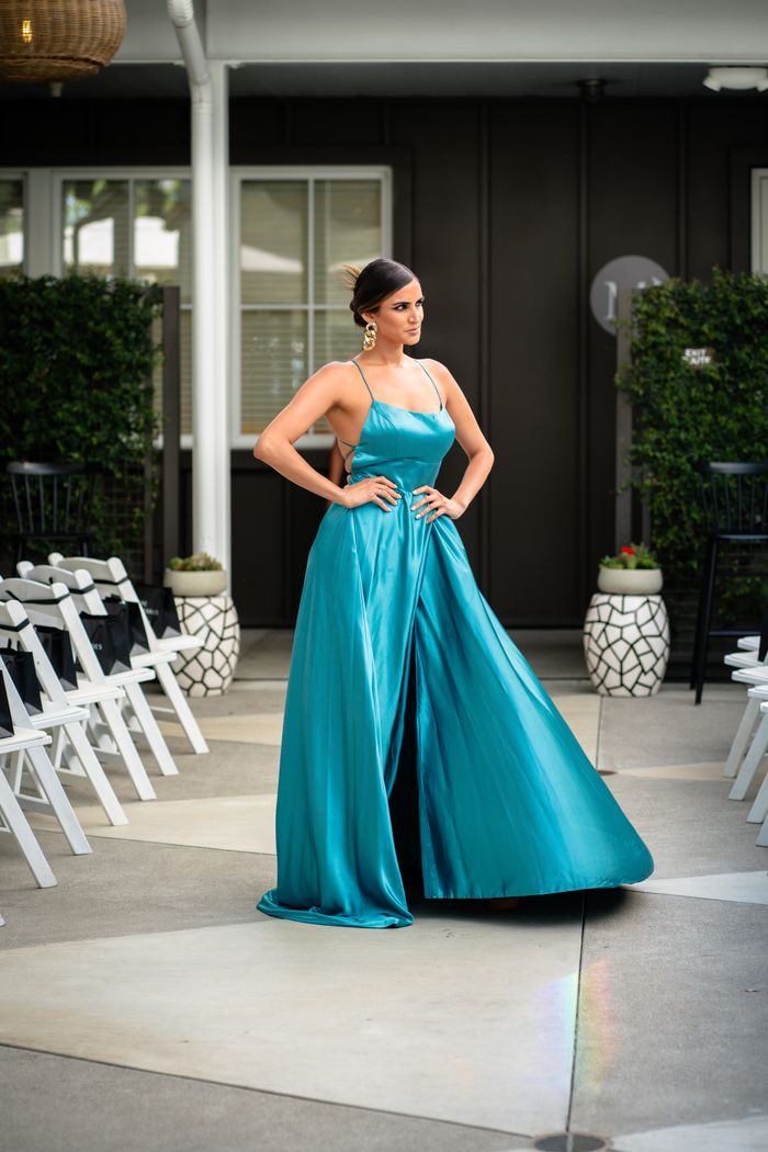 services-04 Woman in a stunning blue dress posing gracefully at an outdoor event. Perfect for fashion themes.